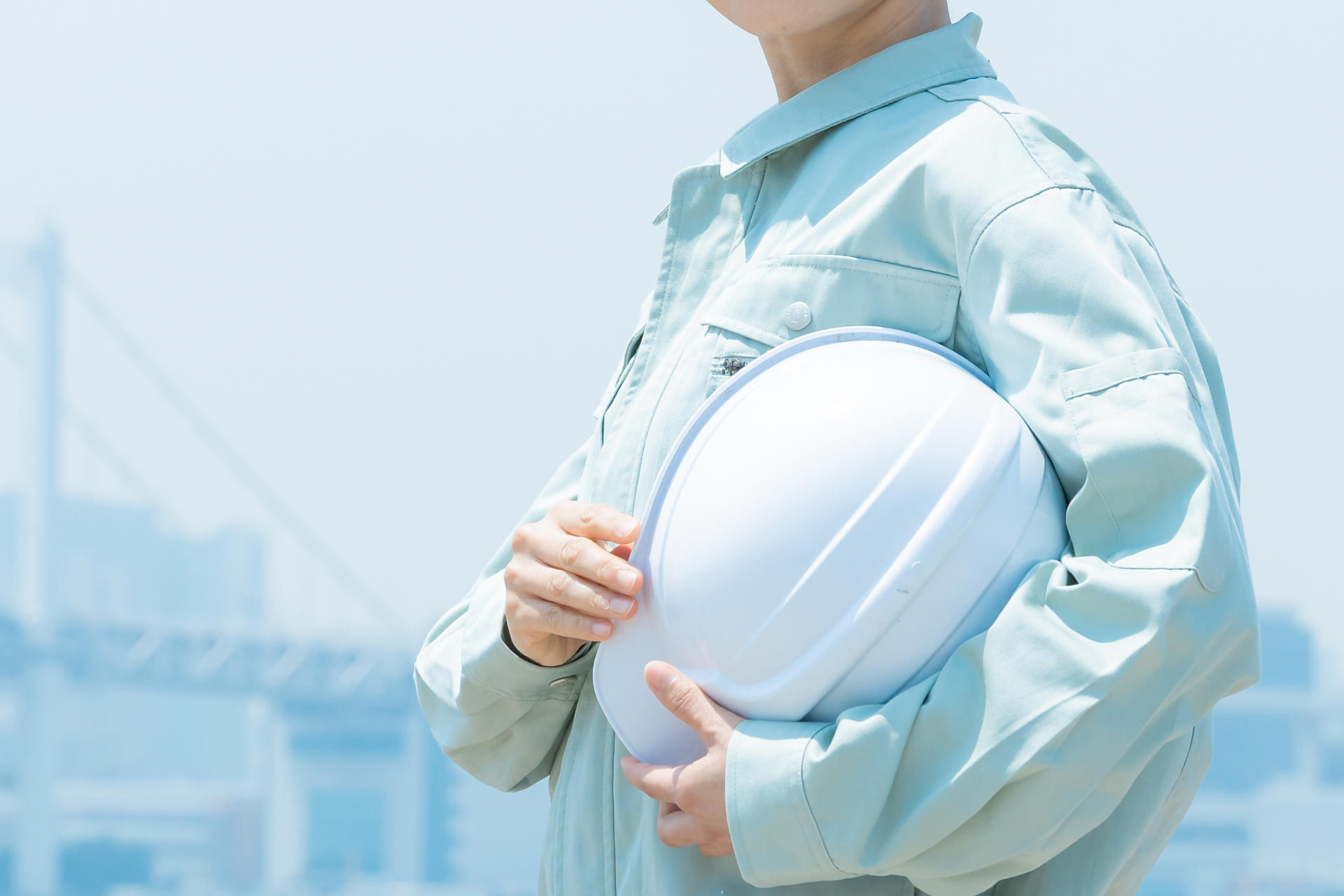 ヘルメットを抱える作業服の人